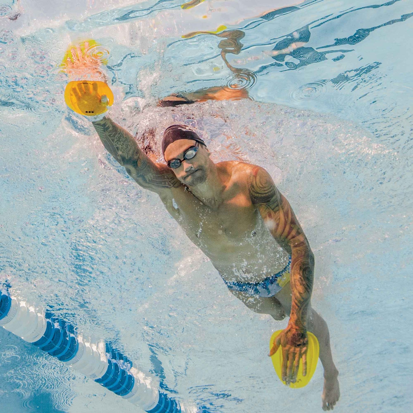 Swimmer using FINIS Floating Agility Paddles underwater during freestyle stroke for strength training