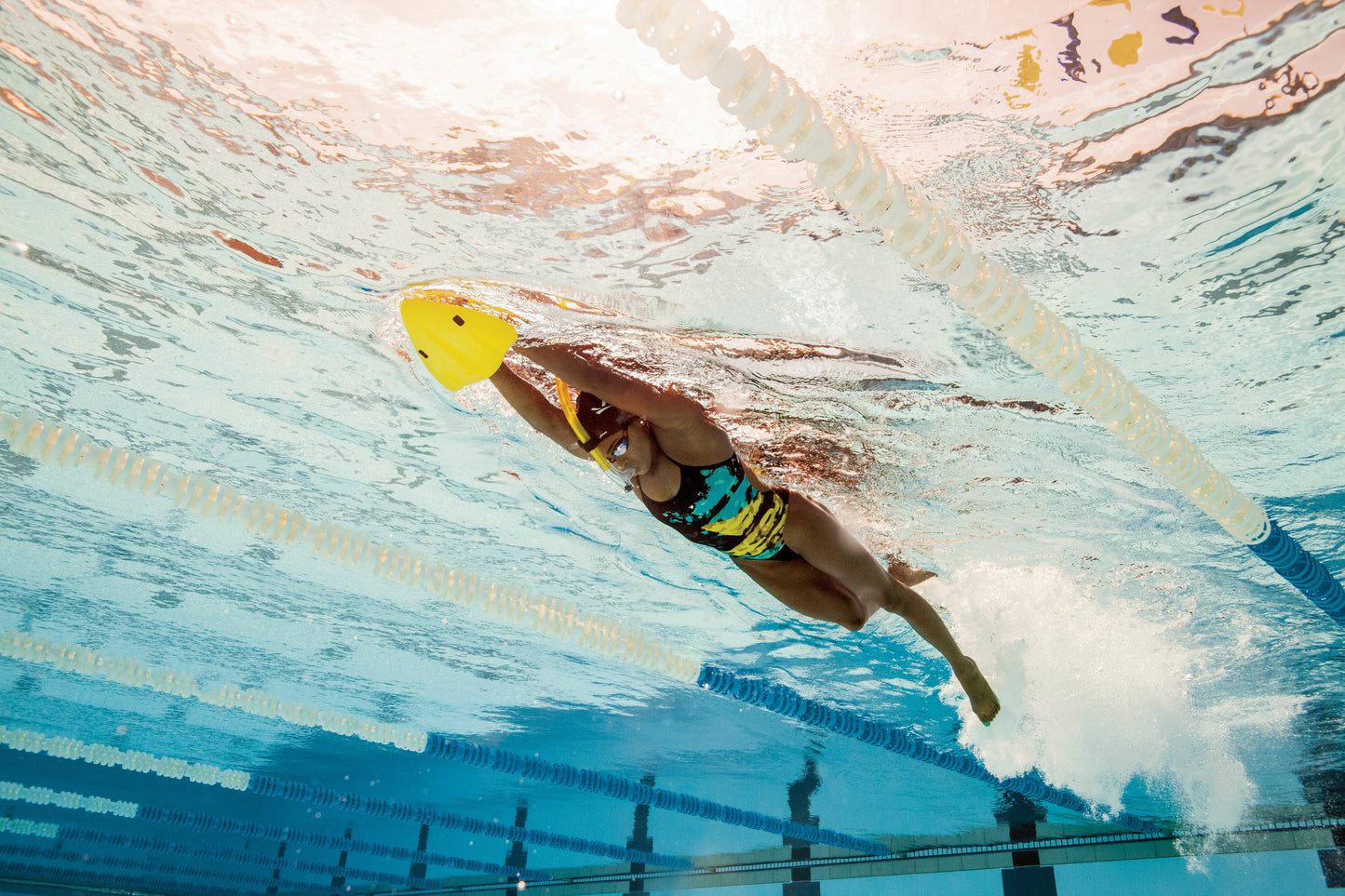 Swimmer using FINIS yellow Alignment Kickboard during underwater swim training