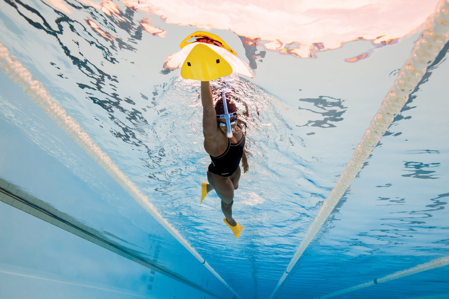 Swimmer holding FINIS Alignment Kickboard vertically for resistance kicking drill