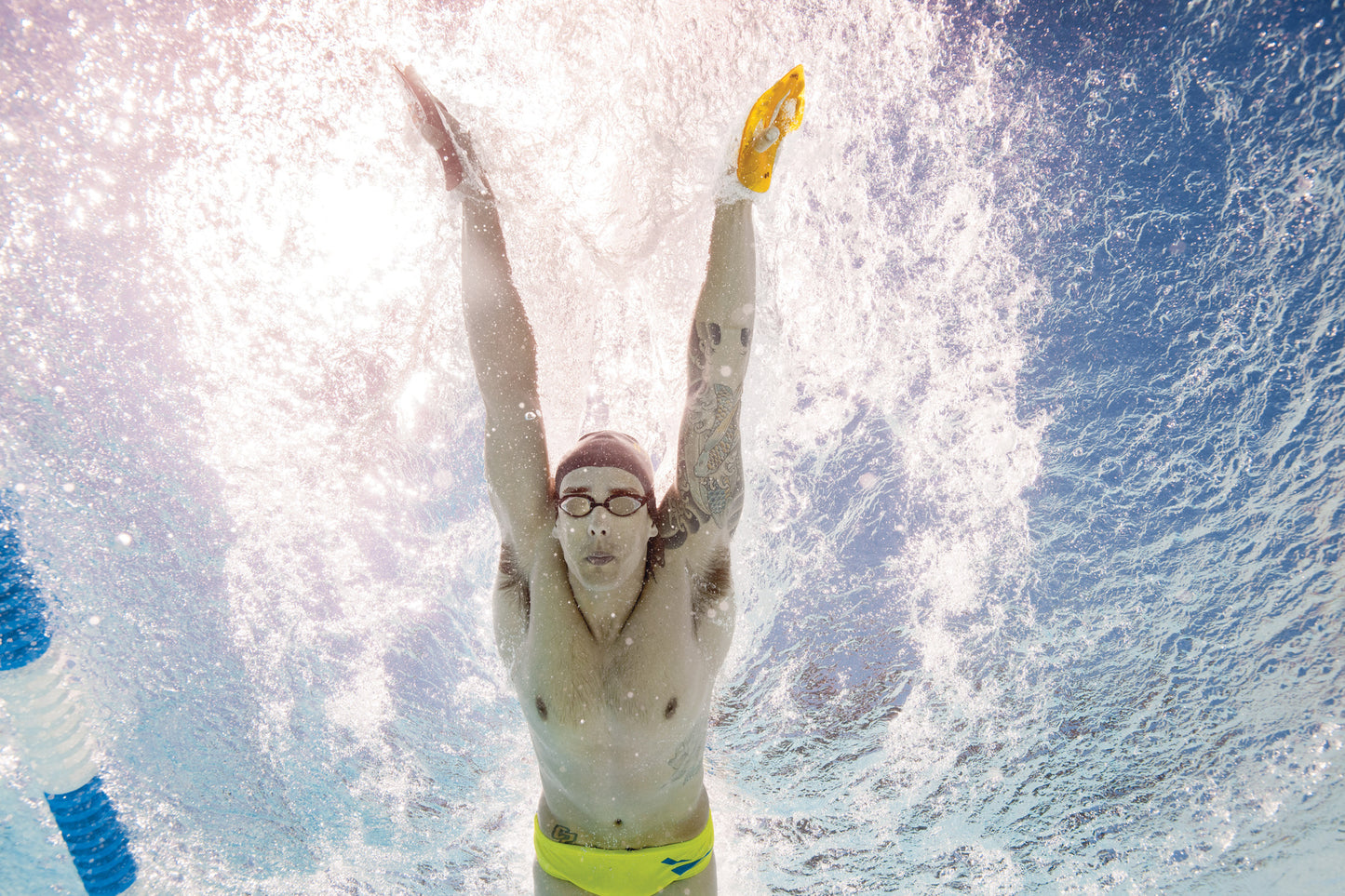Underwater view of swimmer using FINIS Iso Paddles during push-off and streamlining