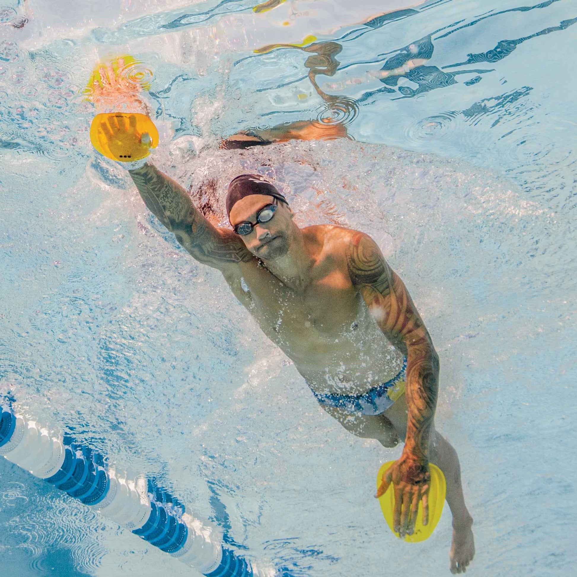 Swimmer using FINIS Floating Agility Paddles underwater during freestyle stroke for strength training