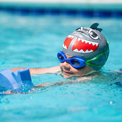 Child wearing FINIS Blueberry scented swim goggles while swimming with kickboard