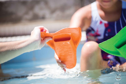 Child wearing FINIS Booster Swim Fins (Junior 8–11, Green) at beachside