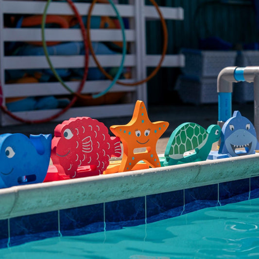 FINIS Turtle hand float on poolside with other Floatie Friends characters