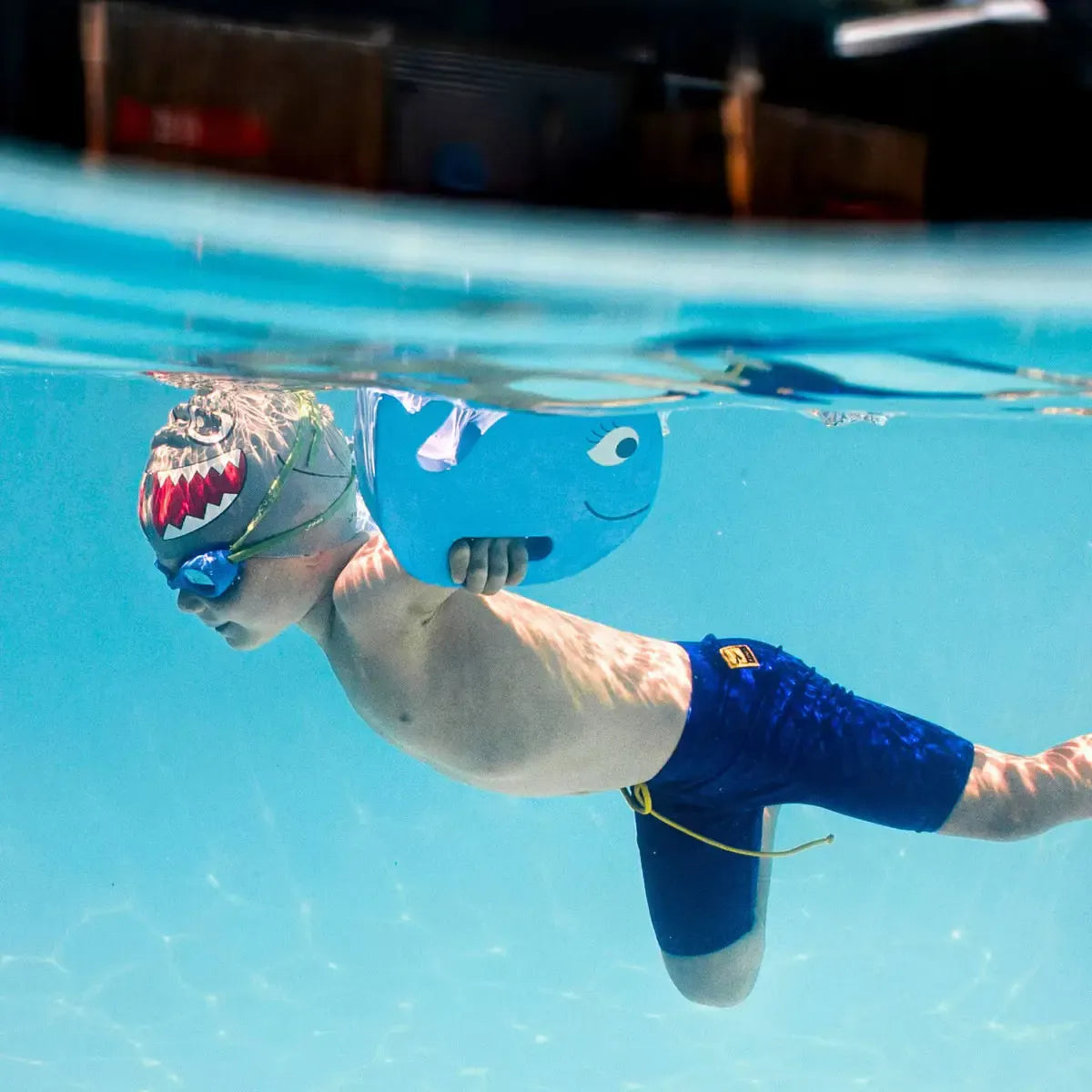 Child using FINIS Floatie Friends Foam Hand Float in Whale Blue during swim training.