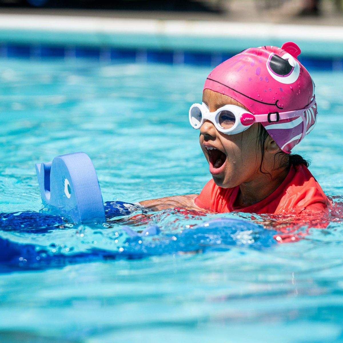Kid learning to swim with FINIS Floatie Friends Foam Hand Float, Whale Blue edition.