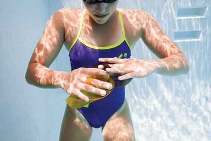 Close-up of swimmer holding FINIS Iso Paddles in water for isolation training