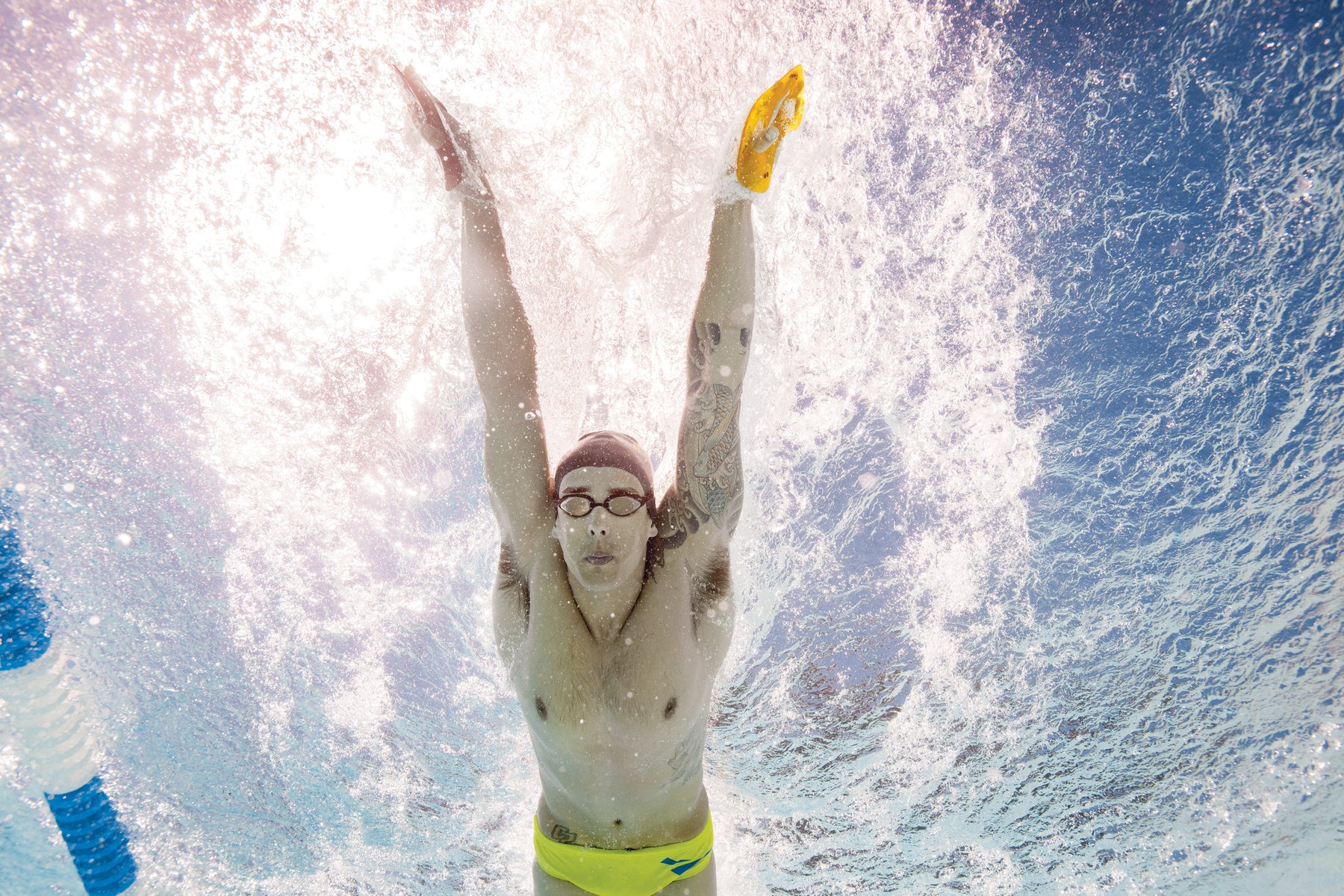 Underwater view of swimmer using FINIS Iso Paddles during push-off and streamlining
