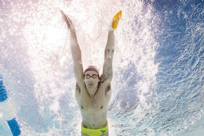 Underwater view of swimmer using FINIS Iso Paddles during push-off and streamlining