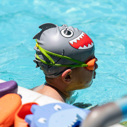 Side view of child in FINIS Fruit Basket Orange goggles wearing shark swim cap