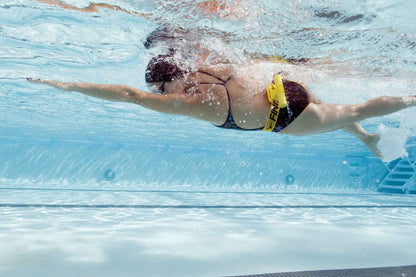 Side view of swimmer wearing FINIS Tech Toc during freestyle stroke for rotation awareness